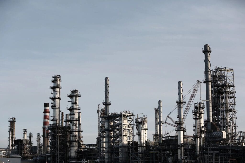 A large oil refinery with many towers and pipes.