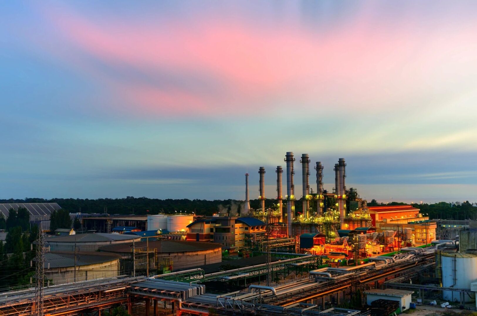 A factory with many pipes and stacks of cars